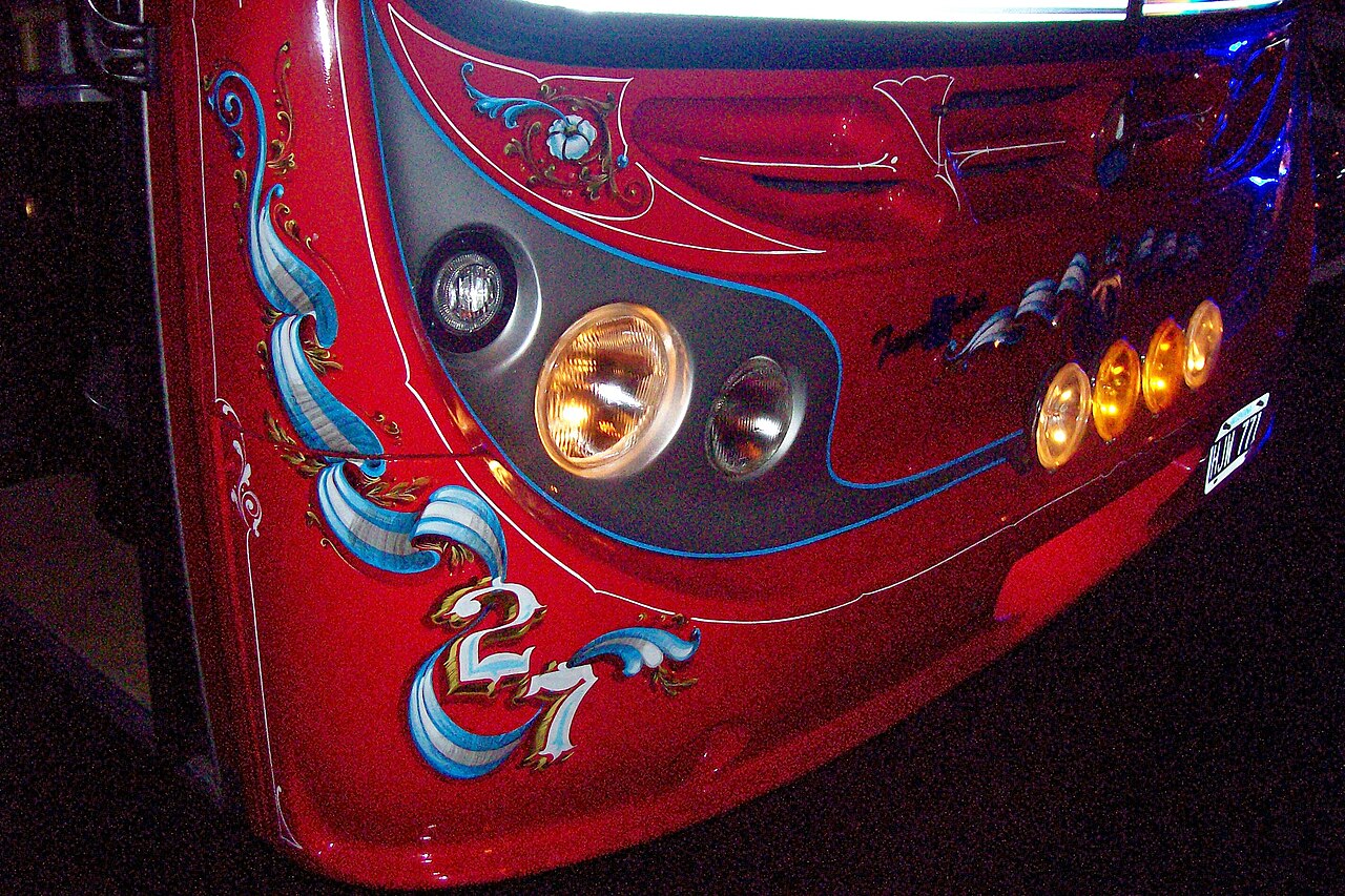 The front of a Buenos Aires colectivo decorated with ornate fileteado scrollwork and colored lines around the destination box.