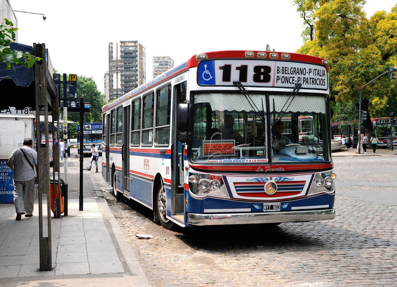A privately-owned Buenos Aires colectivo of line 118 with a bold custom paint scheme on a city street.