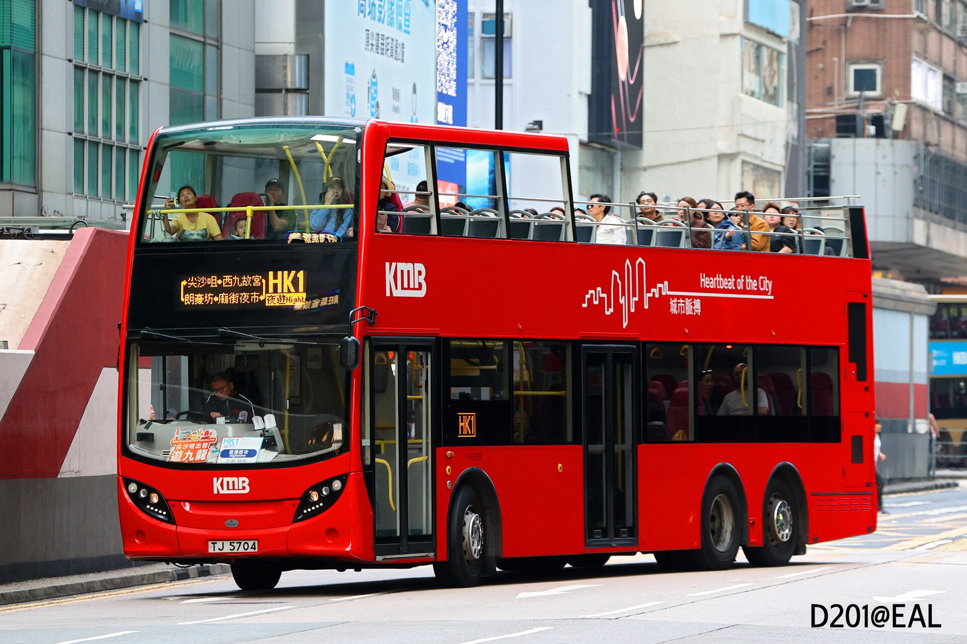 A red KMB Alexander Dennis Enviro500 MMC three-axle double-decker bus on a Hong Kong street.