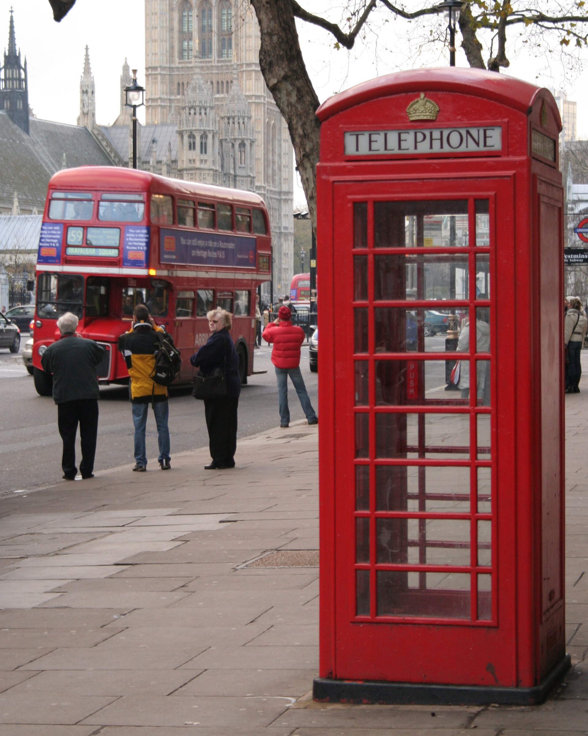 A red Routemaster double-decker on route 159 passing the Palace of Westminster with a red telephone box, London, 8 December 2005.