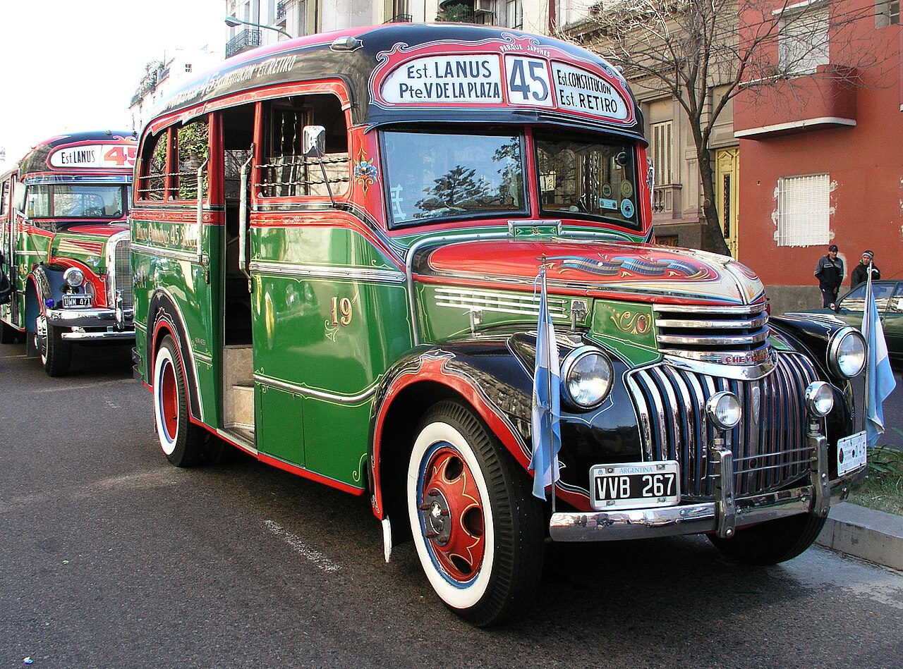 An antique Buenos Aires colectivo of line 45 covered in colorful fileteado porteño painting and ornate lettering.