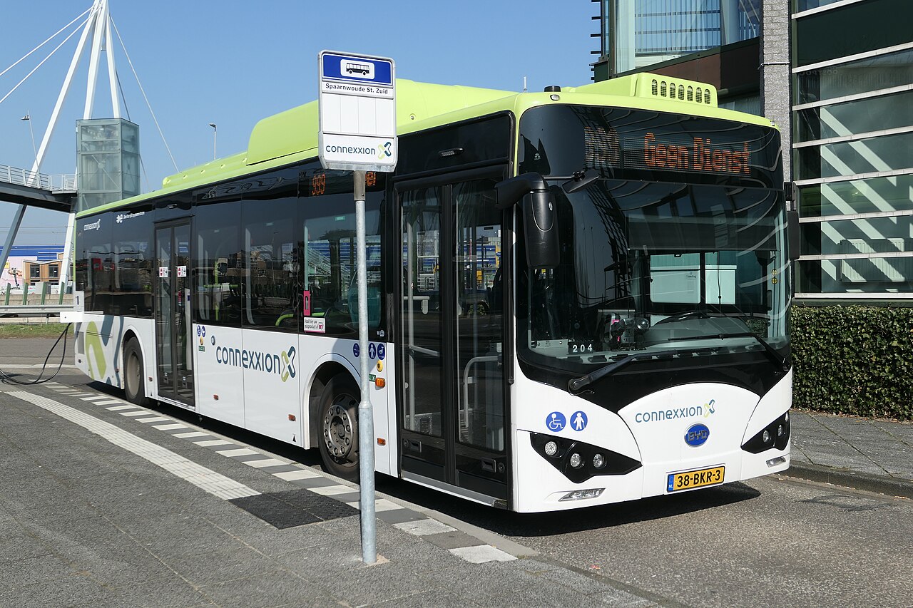A modern white BYD battery-electric city bus operated by Connexxion, parked at a stop.