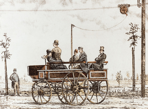 Historic image of the 1882 Siemens Elektromote, a converted carriage drawing power from overhead wires in Berlin-Halensee.