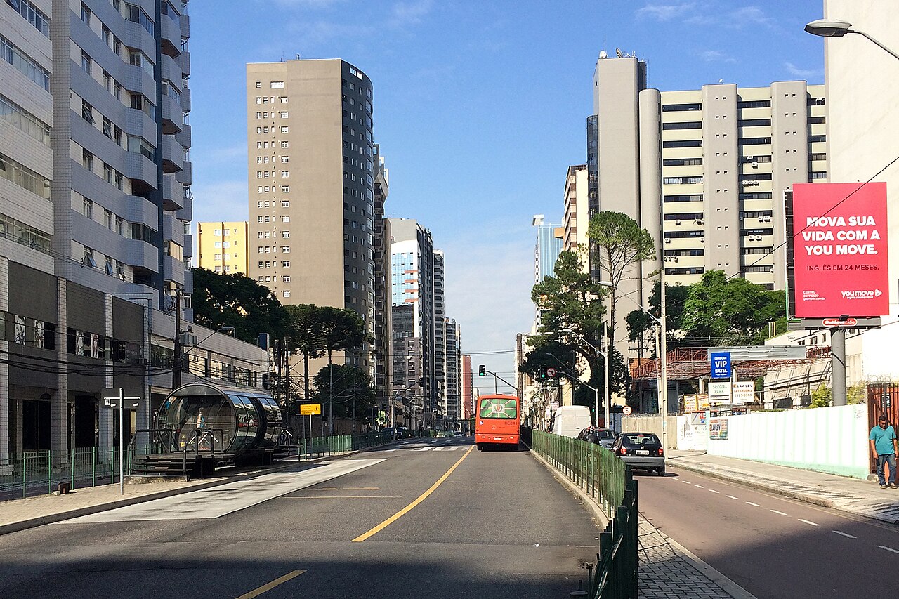 A cylindrical glass tube station on a Curitiba bus rapid transit corridor in Brazil