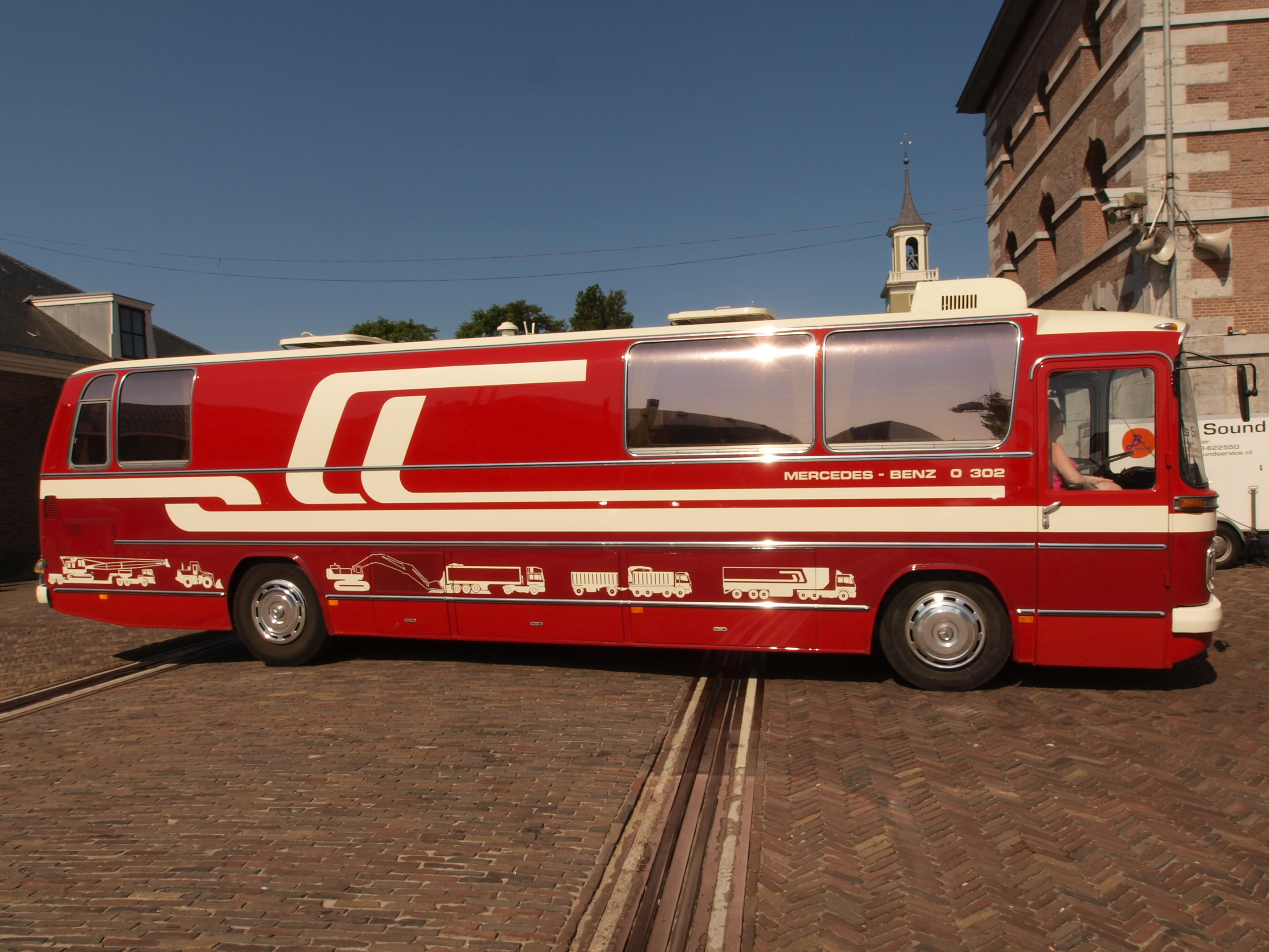 A restored red and cream Mercedes-Benz O302 coach in standard production form, with 'Mercedes-Benz O 302' lettering along the side.