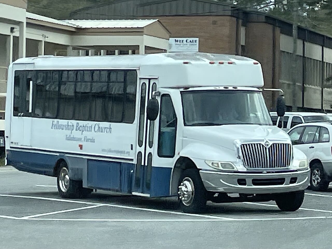 A cutaway shuttle bus: a boxy bus body mounted on a light-truck van chassis