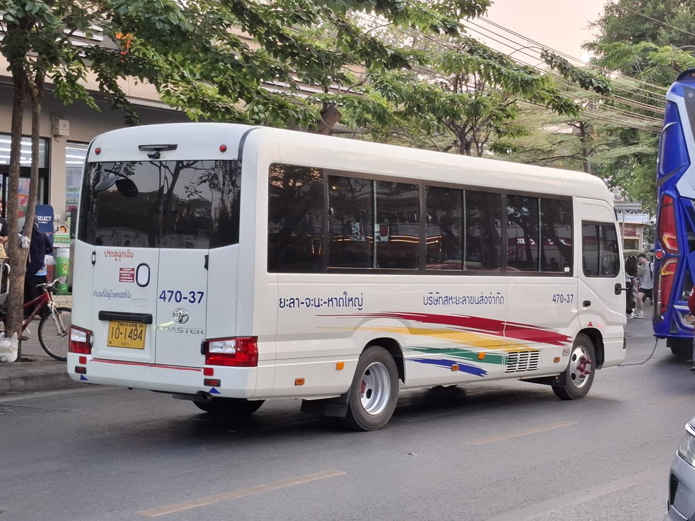 A white Toyota Coaster minibus parked on a street, one of the world's most common small buses