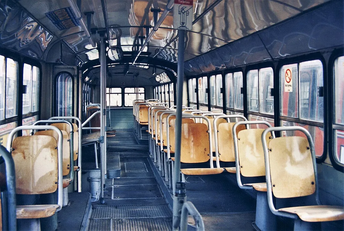 The passenger interior of an articulated Pegaso 6035-A, bus 3005 of Transports de Barcelona, showing rows of wooden-panelled seats.
