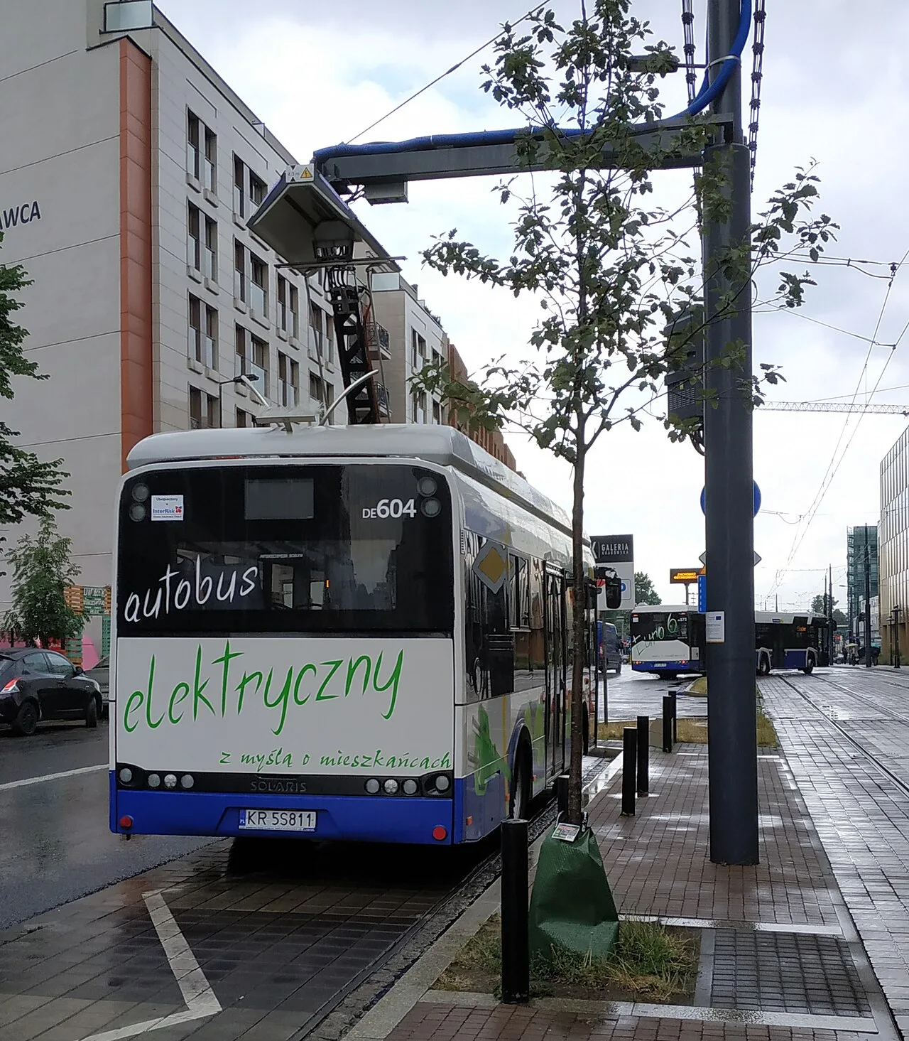 A Solaris Urbino electric bus charging from an overhead pantograph in Kraków, Poland.