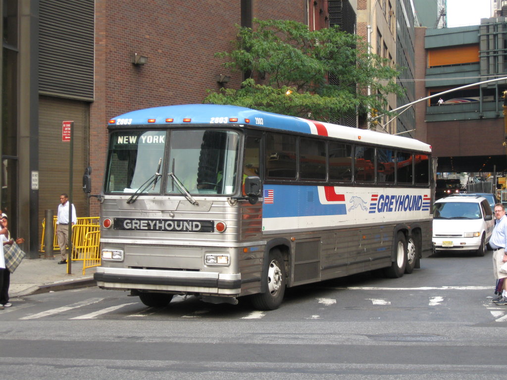 A classic silver Greyhound MCI MC-12 intercity coach leaving the Port Authority Bus Terminal in New York.