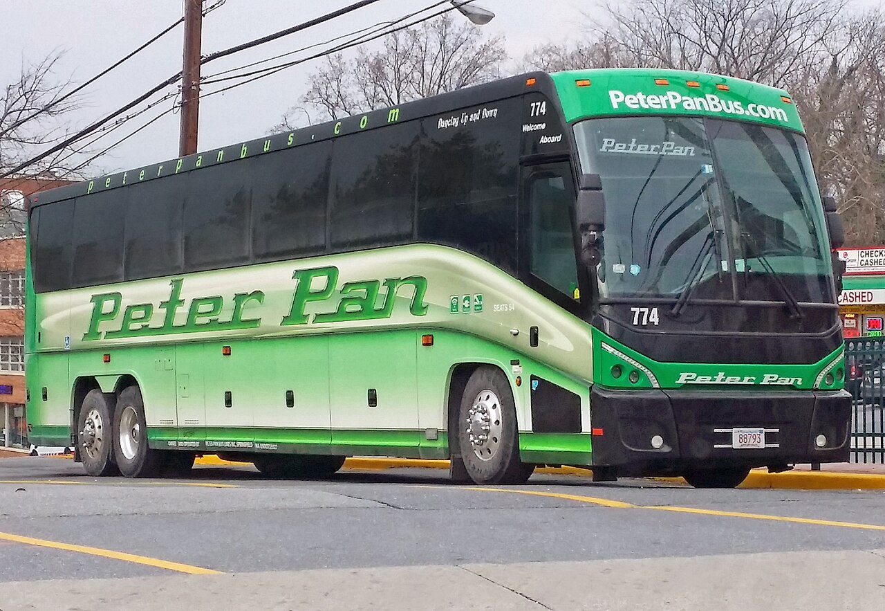 A modern white MCI J4500 motorcoach operated by Peter Pan Bus Lines at a terminal in Maryland.