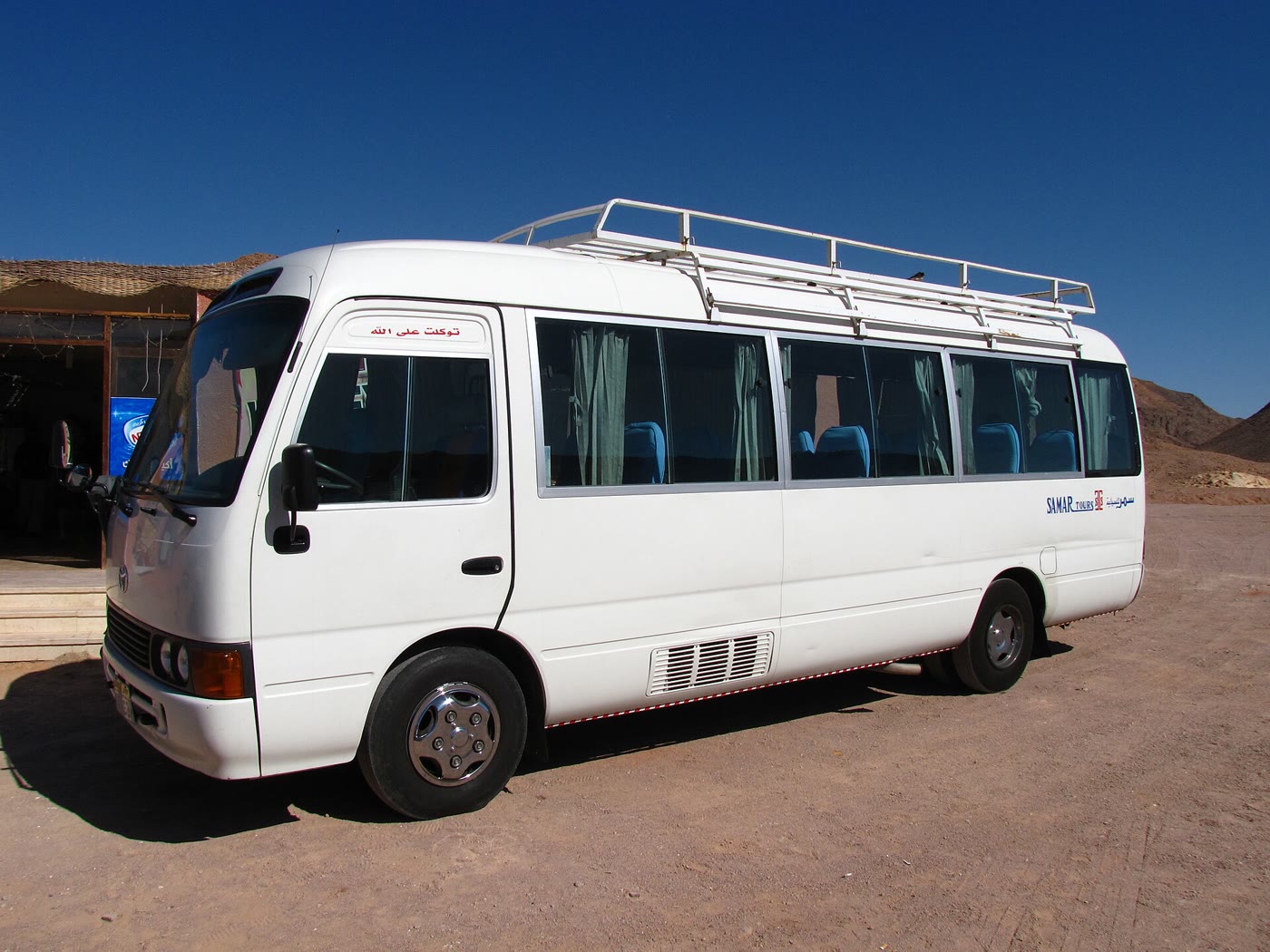 A white Toyota Coaster minibus on a street in Egypt, a common sight across the developing world