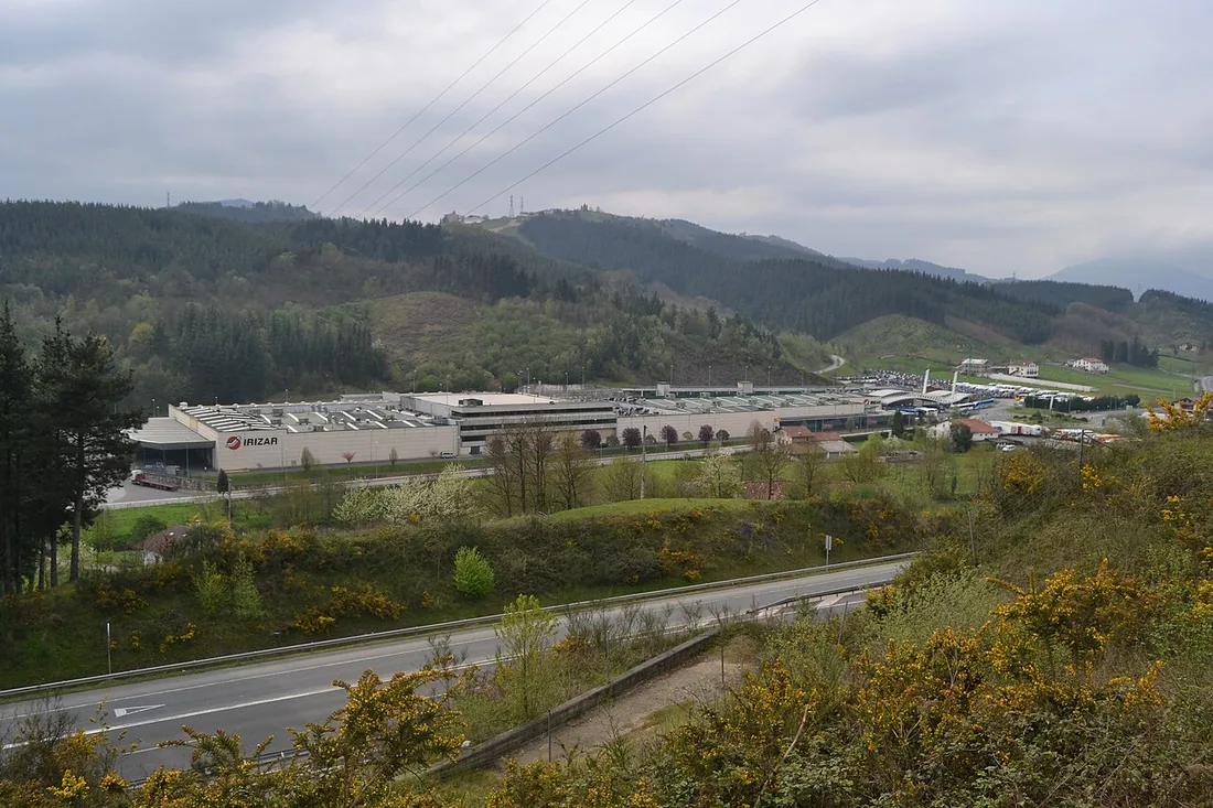 The Irizar factory at Ormaiztegi in the Basque Country, seen from the road with the green hills behind it.