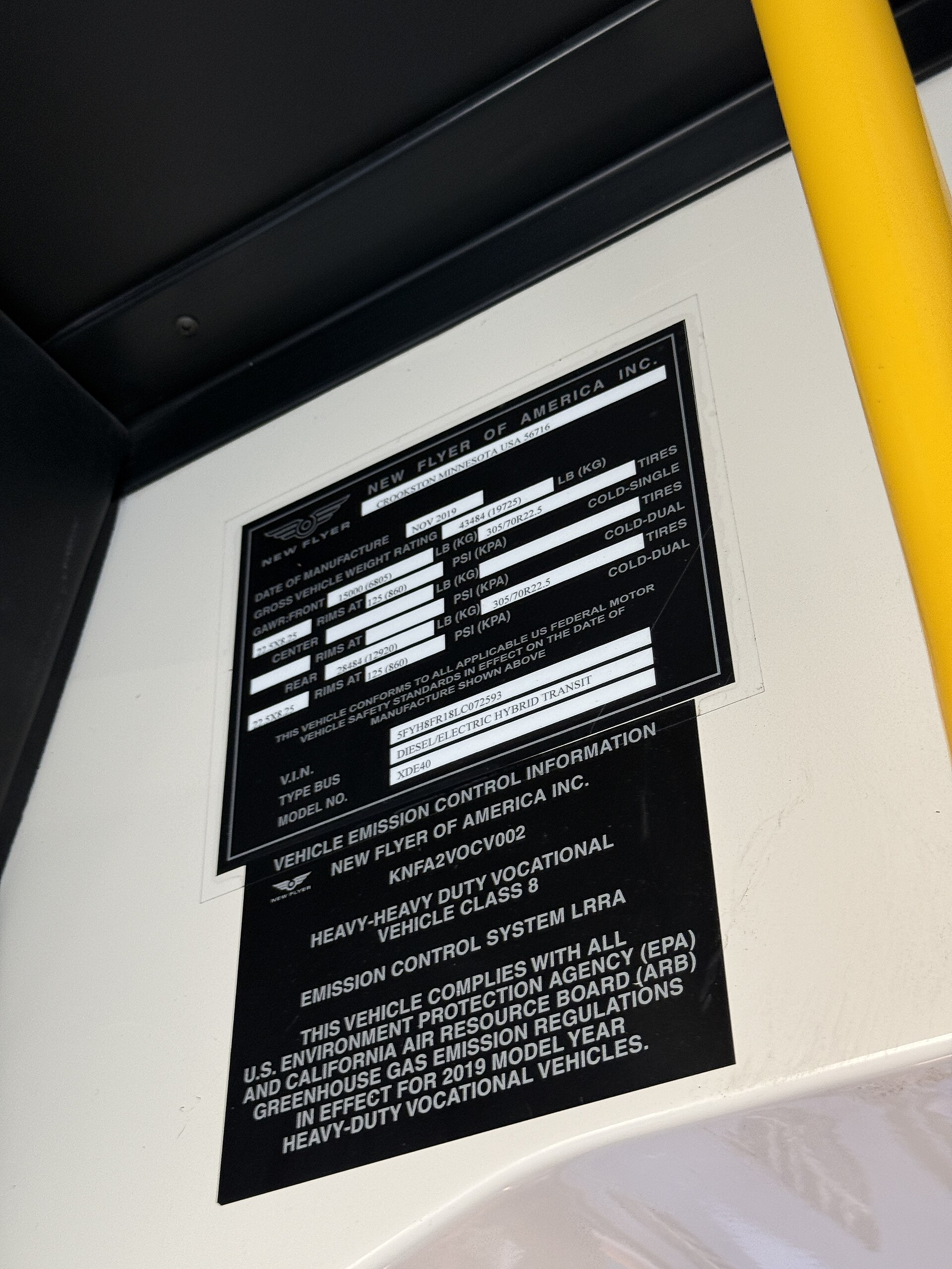 The builder's plate on an MBTA New Flyer XDE40 hybrid bus, showing the model code stamped on the vehicle.
