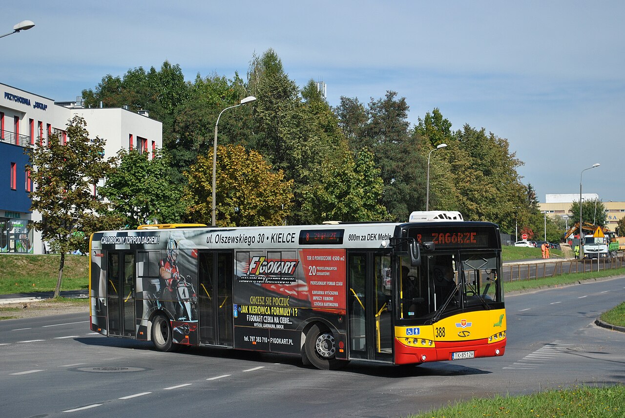 Front of a Solaris Urbino 12 bus in Kielce, Poland, showing the small green dachshund mascot logo on the front panel.