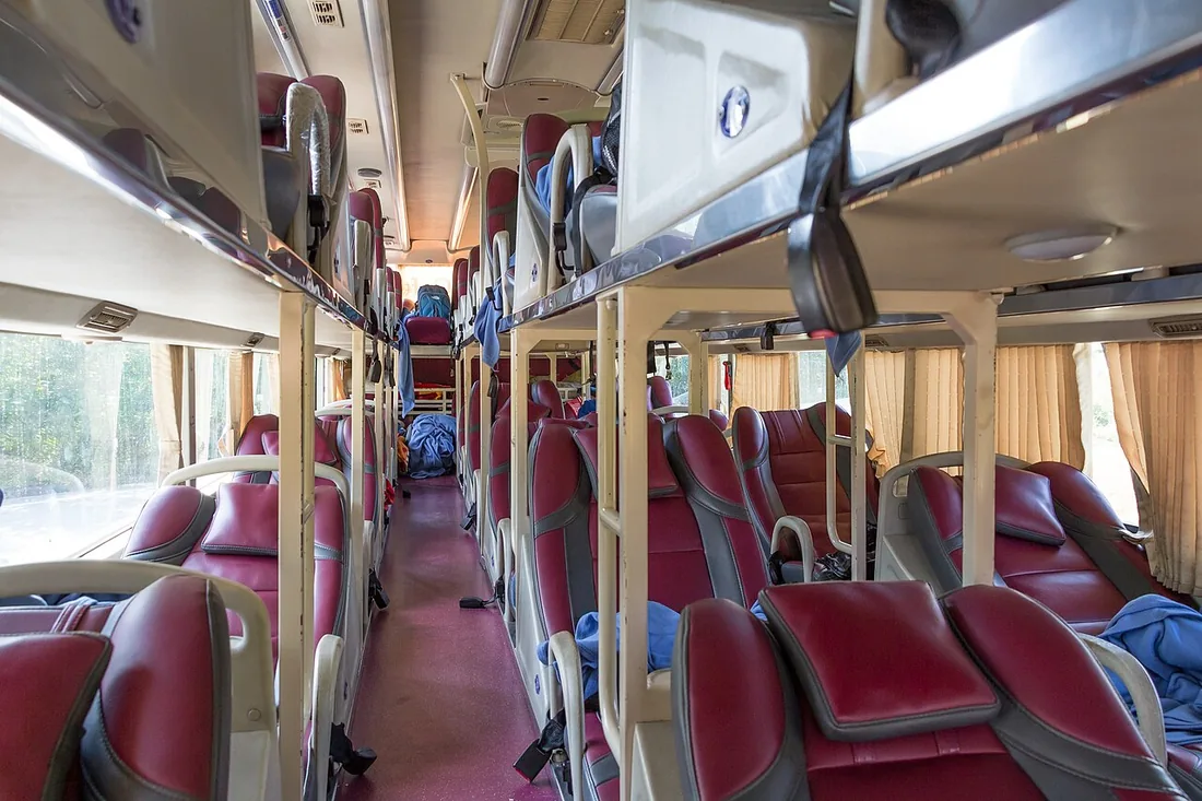 The bunk-lined interior of a Thaco Mobihome sleeper coach in Vietnam, with stacked flat beds instead of seats.