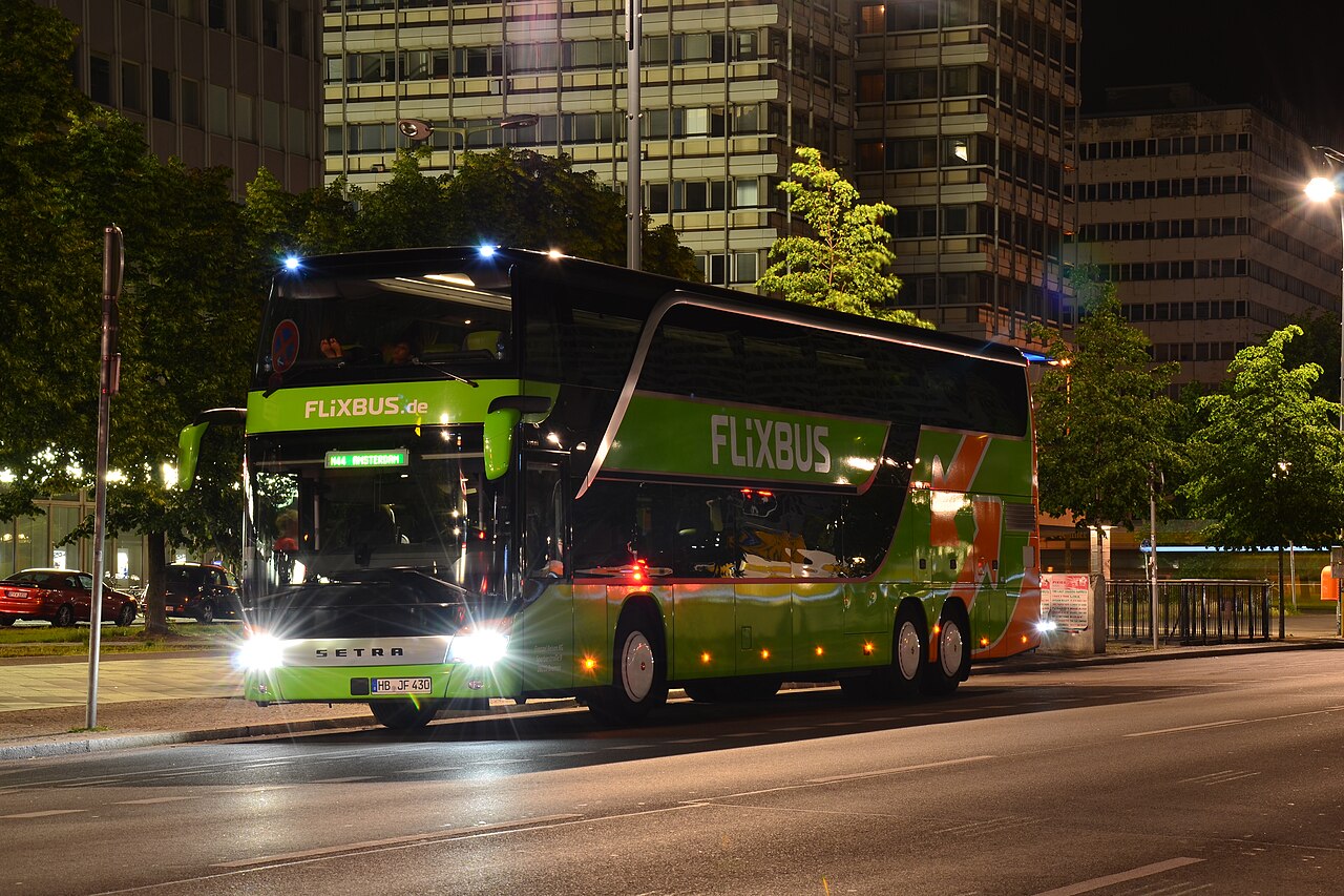 A green FlixBus Setra double-decker coach at night in Berlin.
