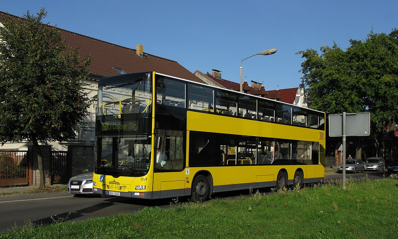 A modern yellow BVG double-decker bus, a MAN Lion's City DD, on a Berlin street