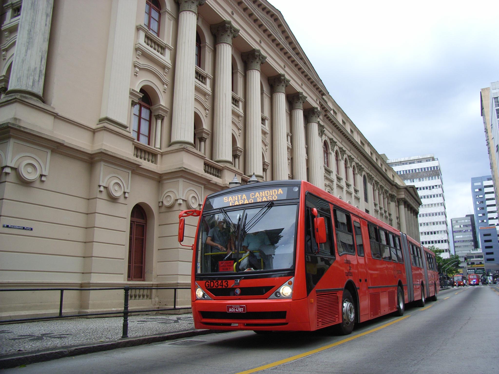 A 25-metre bi-articulated CAIO Millennium bus on a Volvo B12M chassis serving a Curitiba bus rapid transit corridor in Brazil.