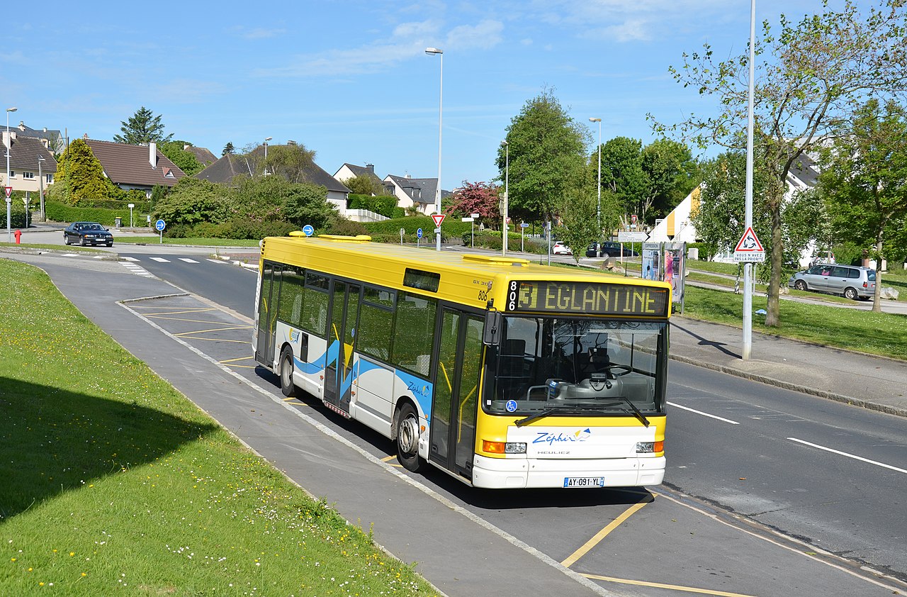 A white Heuliez GX 317 low-floor city bus in a French town.