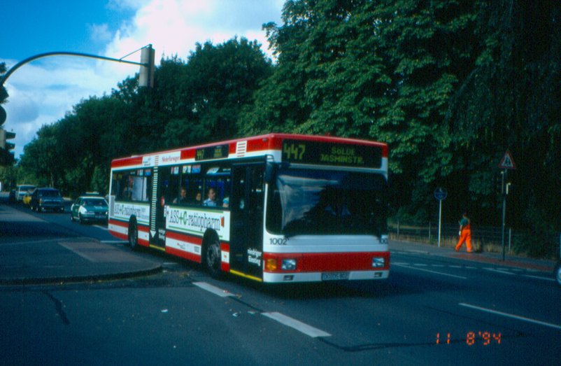 A red and white MAN NL202 low-floor city bus on route 447 in Dortmund, Germany, in 1994.
