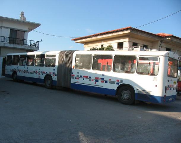 A white and grey Mercedes-Benz O305 standard city bus seen from the side in Greece.