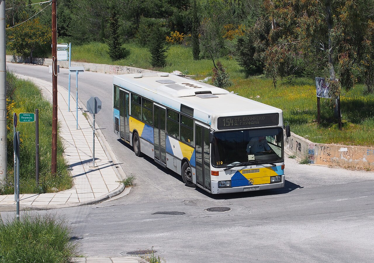 A low-floor Mercedes-Benz O405N city bus in blue, yellow and white Athens livery.