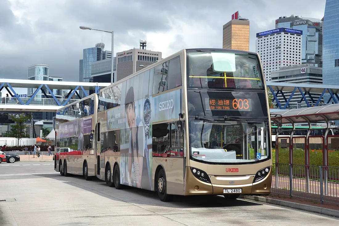 A row of red Kowloon Motor Bus double-deckers lined up at a terminus near the Star Ferry pier in Central, Hong Kong.