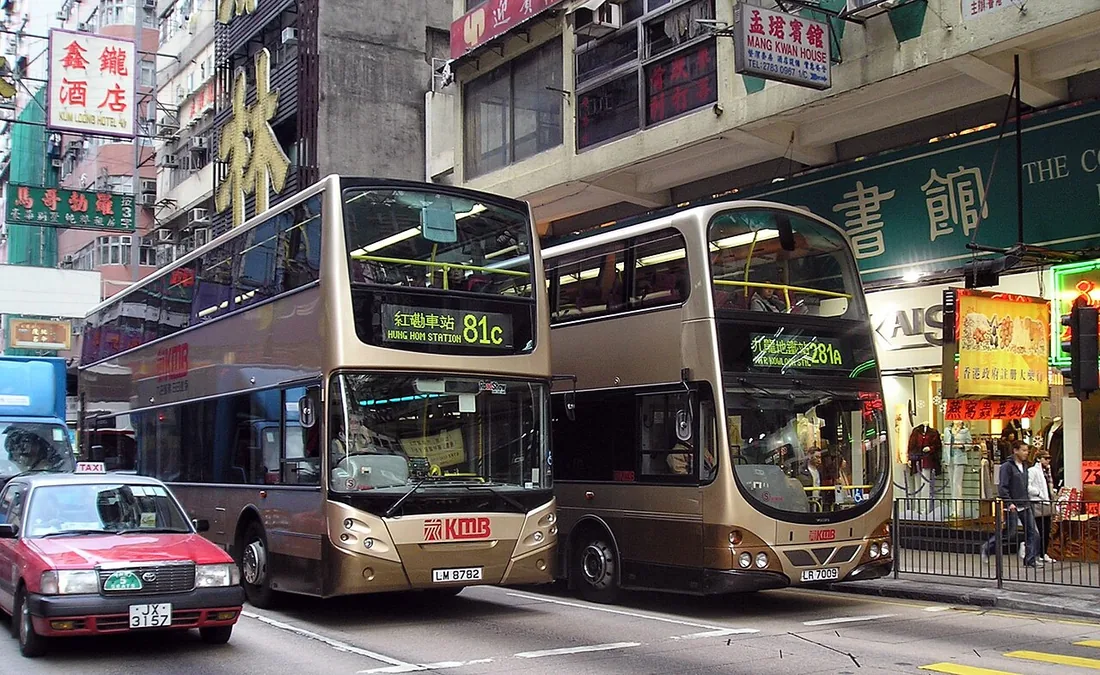 Two Kowloon Motor Bus double-decker buses on Nathan Road in Kowloon, Hong Kong, in dense traffic.
