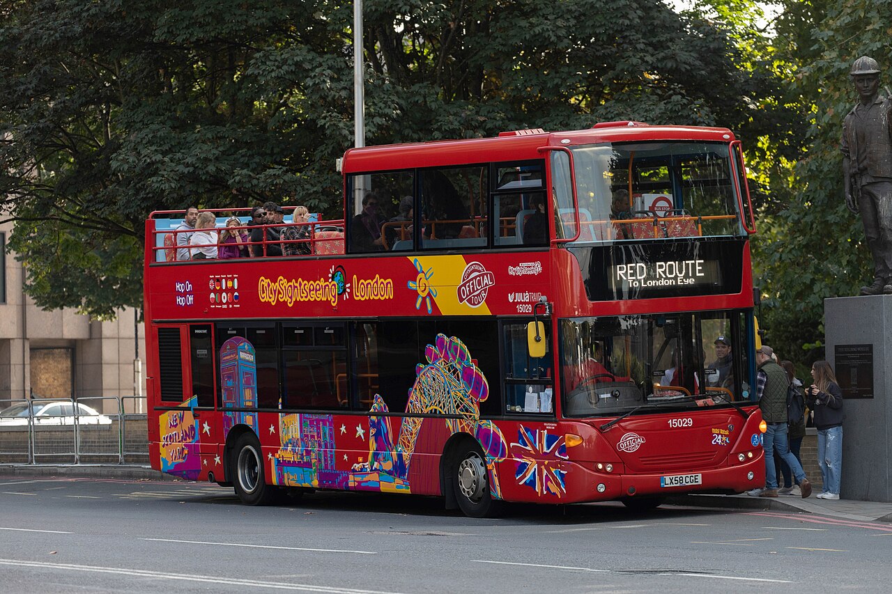 A red open-top City Sightseeing double-decker bus in London