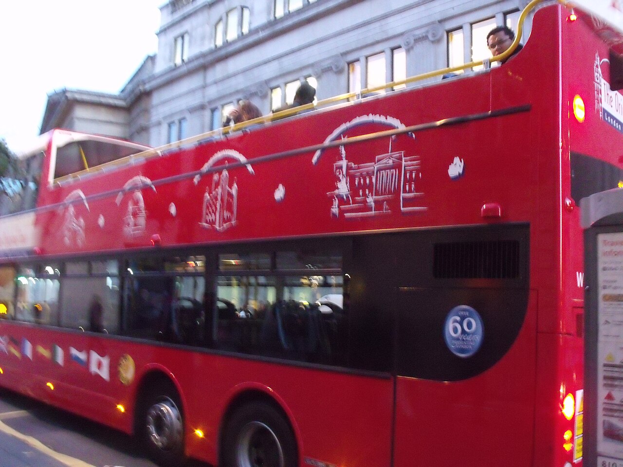 A red open-top double-decker sightseeing bus of The Original London Sightseeing Tour on Pall Mall East, London.